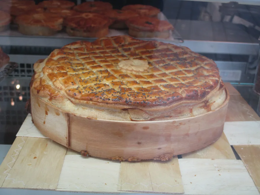 Grande tourte lorraine dorée à croisillons dans la vitrine d'un charcutier