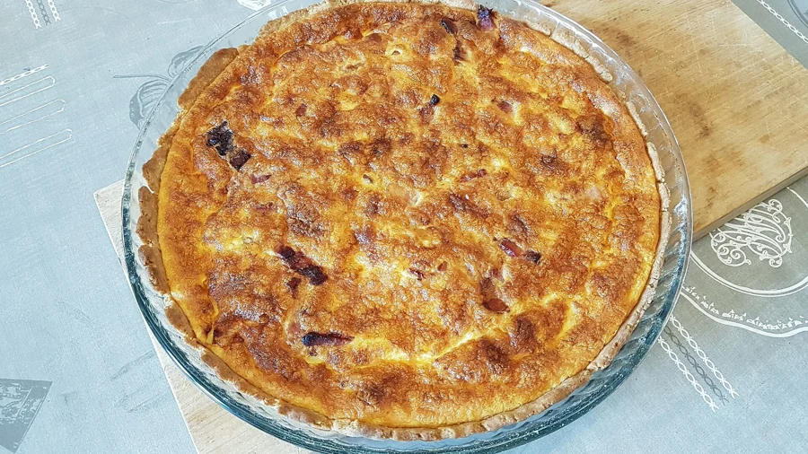 Quiche lorraine dorée dans son plat en verre, sortie du four