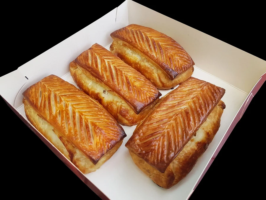 Quatre pâtés lorrains dorés dans une boîte en carton, produit frais d'un panier garni lorrain