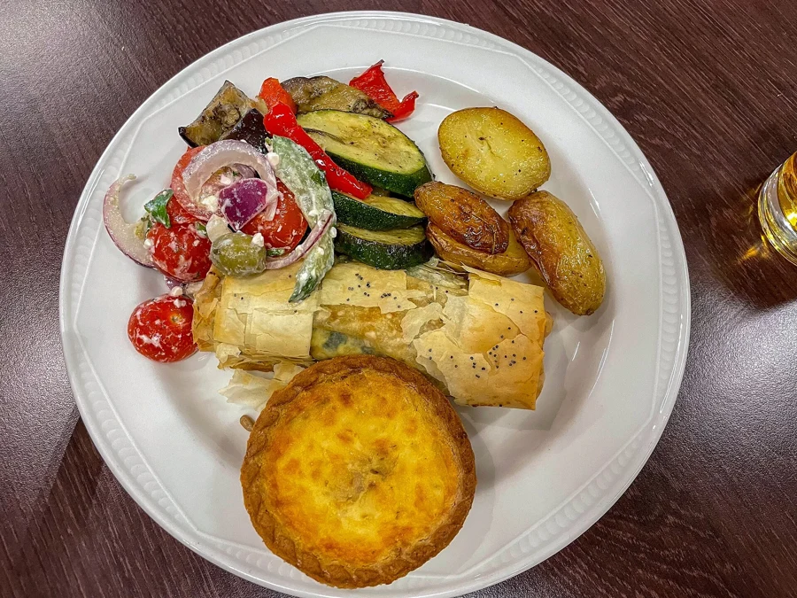 Mini quiche dorée servie avec des légumes grillés dans une assiette