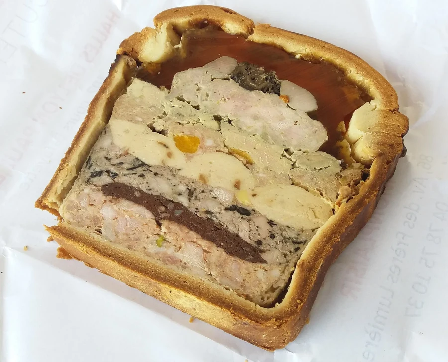 Part de pâté en croûte à la viande, farce rosée et croûte dorée